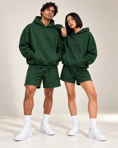 Two models in the Forest green hoodie and mesh shorts